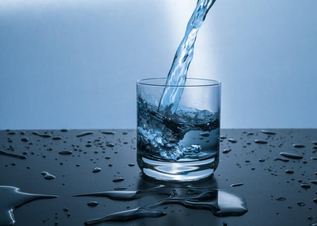 A glass of water is being poured into a glass.