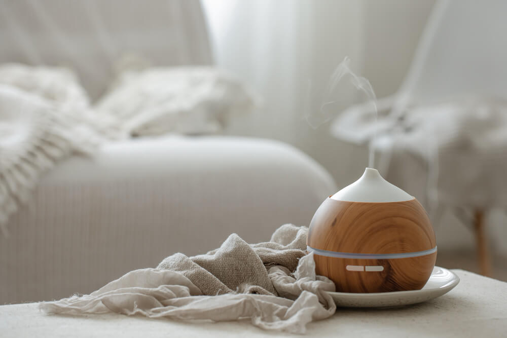 An essential oil diffuser sitting on a bed.