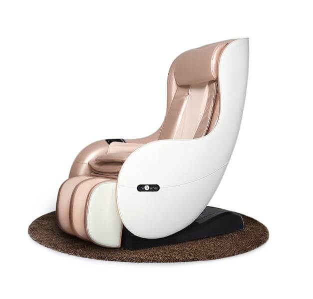 A white and rose gold massage chair sits on a round brown rug.