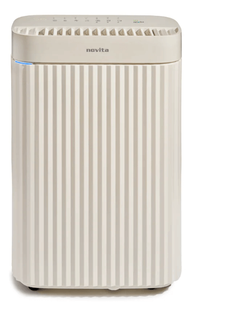 A beige Novita air purifier with vertical grooves, a control panel on top, and a small blue indicator light on the front doubles as a powerful dehumidifier for cleaner, drier air.
