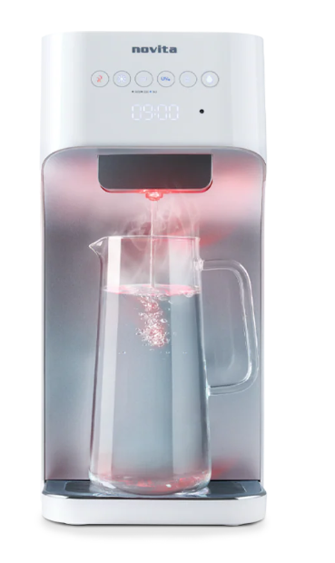 A countertop hot and cold water dispenser in Singapore dispenses steaming hot water into a transparent glass jug, with steam rising beautifully under a glowing red light indicator.