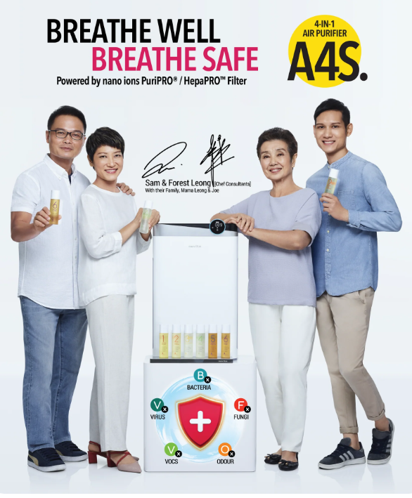 Four adults stand around an air purifier, each holding a canned beverage. The purifier—identified as the Novita A8i, one of the leading air cleaners in Singapore—displays icons for bacteria, virus, fungus, VOCs, and odour, with product branding and text above.