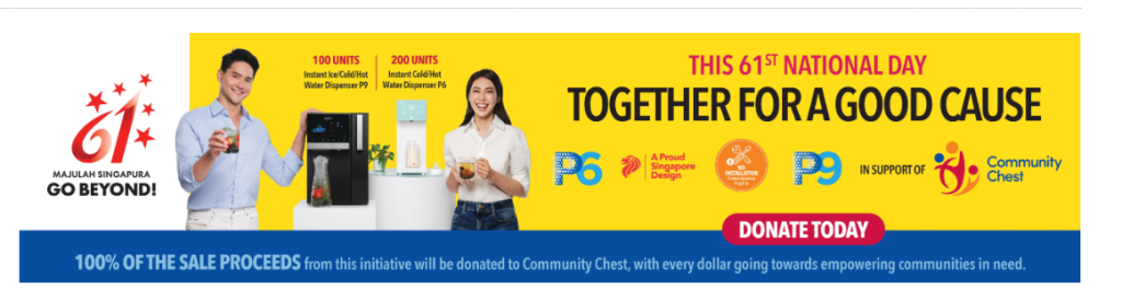 Three people hold drinks beside a water cooler promoting a National Day Promotion charity drive; the banner urges donations for a Good Cause, with proceeds supporting Community Chest.